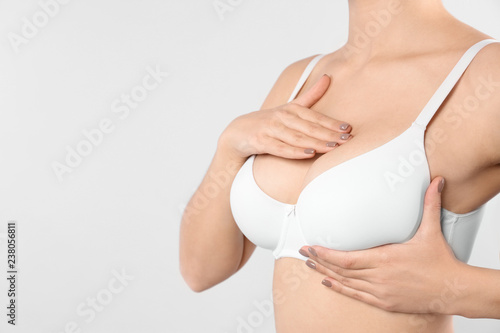 Woman checking her breast on white background, closeup. Space for text