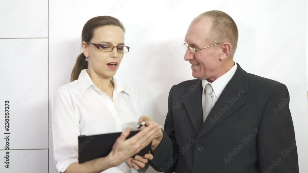 4K. Businessman explains to business lady, how to make contract 4K. Businessman explains to business lady, how to make contract