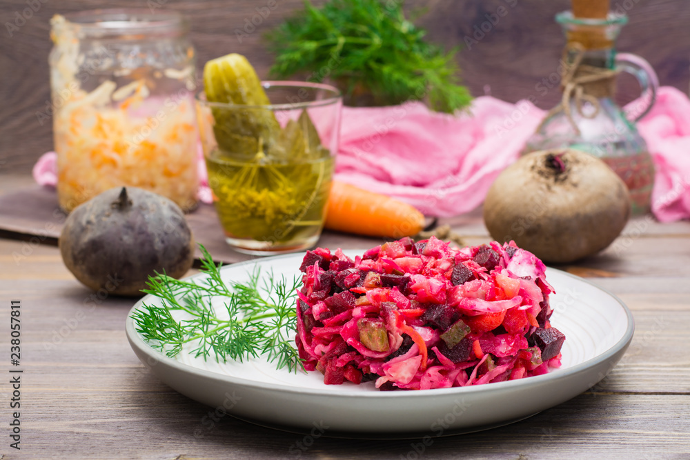 National Russian salad - vinaigrette - from boiled vegetables, sauerkraut and pickled cucumbers on a plate on a wooden table National Russian salad - vinaigrette - from boiled vegetables, sauerkraut and pickled cucumbers on a plate on a wooden table