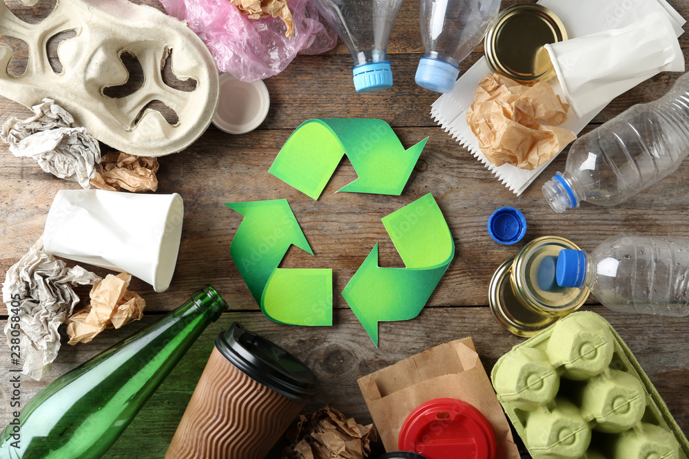 Recycling symbol and different garbage on wooden background, top view - obrazy, fototapety, plakaty 