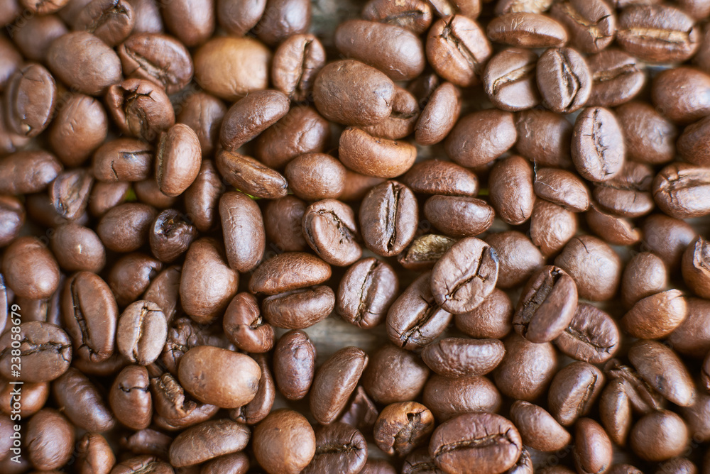 Roasted coffee beans on rustic wooden background. Food ingredients, top view, space for text Roasted coffee beans on rustic wooden background. Food ingredients, top view, space for text