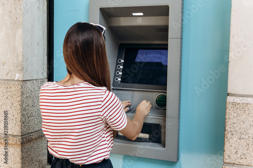 A young woman takes money from an ATM. Finance, credit card, withdrawal of money. Life style. Grabs a card from the ATM.