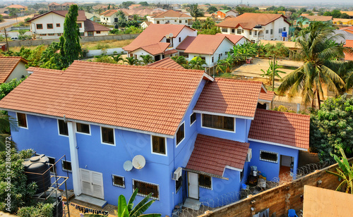 Residential area in West Africa. Top view on family houses, yards with gardens, surrounded by fences & roads. Modern lifestyle in developing countries. Beautiful urban landscape. Ghana, Accra, Tema 