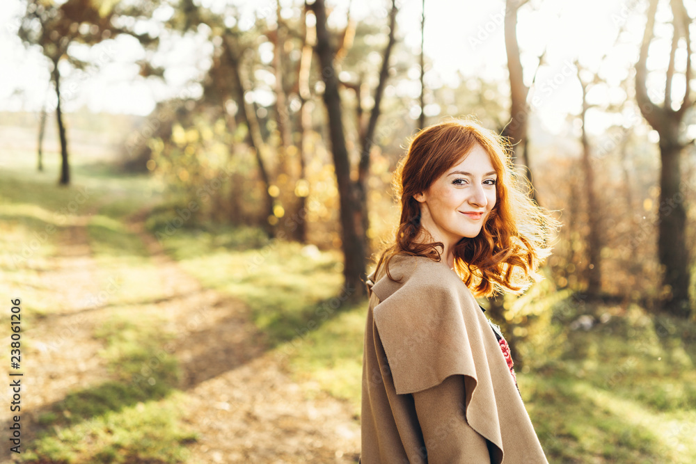 Pretty and happy red hair girl walking in the forest Pretty and happy red hair girl walking in the forest