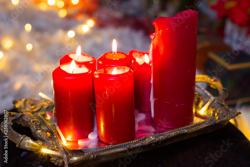 Six red candles on the silver tray with ornaments, fire on the candles, burning, lights as bokeh on the background, Christmas decorations, romantic night, valentines day