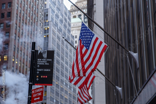 NEW YORK CITY, NY - AUGUST 21, 2014: Famous Wall street and the building in New York, New York Stock Exchange with patriot flag