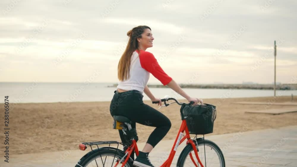 Woman riding bicycle along beach sand at summer time. Healthy and sport concept Woman riding bicycle along beach sand at summer time. Healthy and sport concept