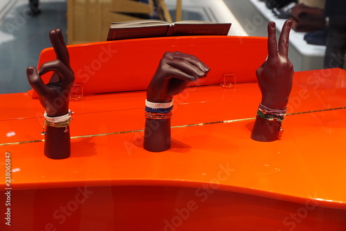hands showing signs standing on the top of a red piano