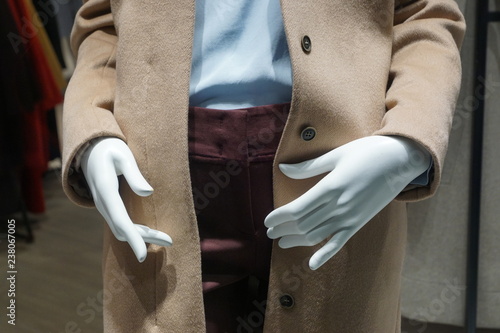 middle part of mannequin's body in beige coat, blue shirt and violet jeans