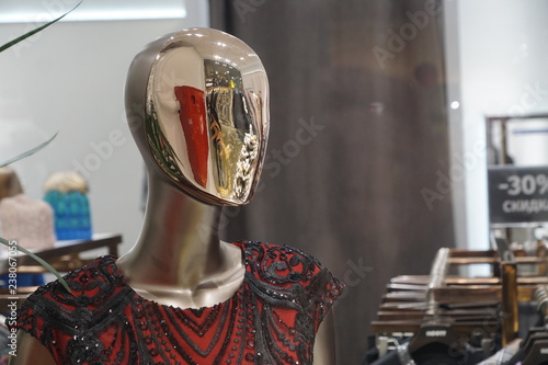 mannequin's metallic head with red and golden reflection in it and black lace blouse