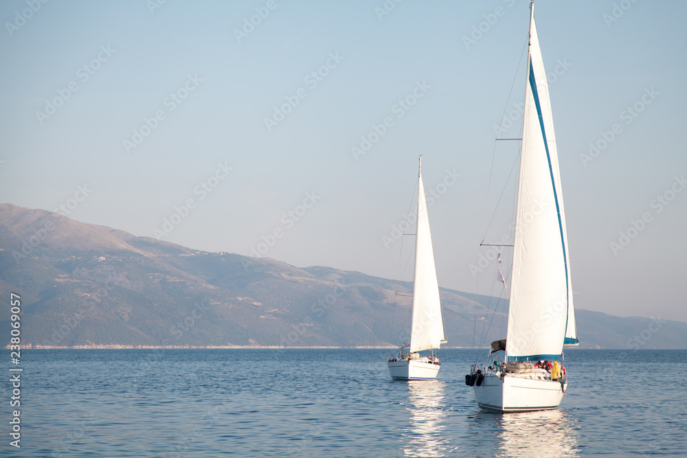 Obraz premium Two sailing yachts are on the sea. Seascape and mountains.