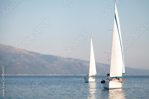  Two sailing yachts are on the sea. Seascape and mountains. © Denys