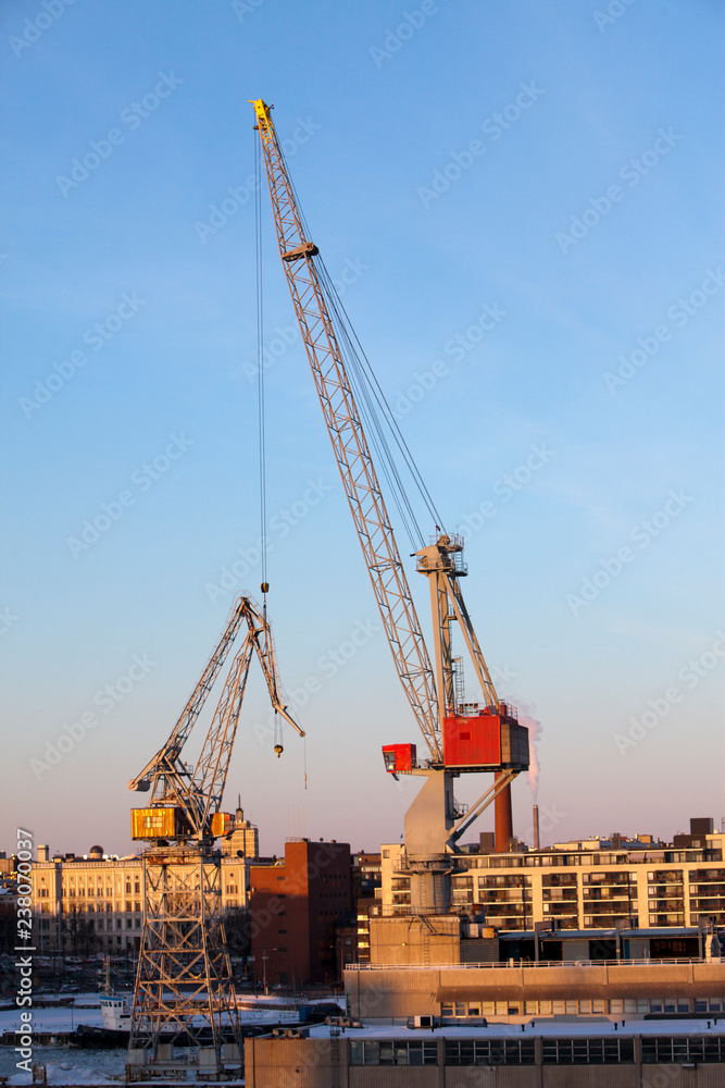 Construction cranes work in the port of Helsinki in winter Construction cranes work in the port of Helsinki in winter
