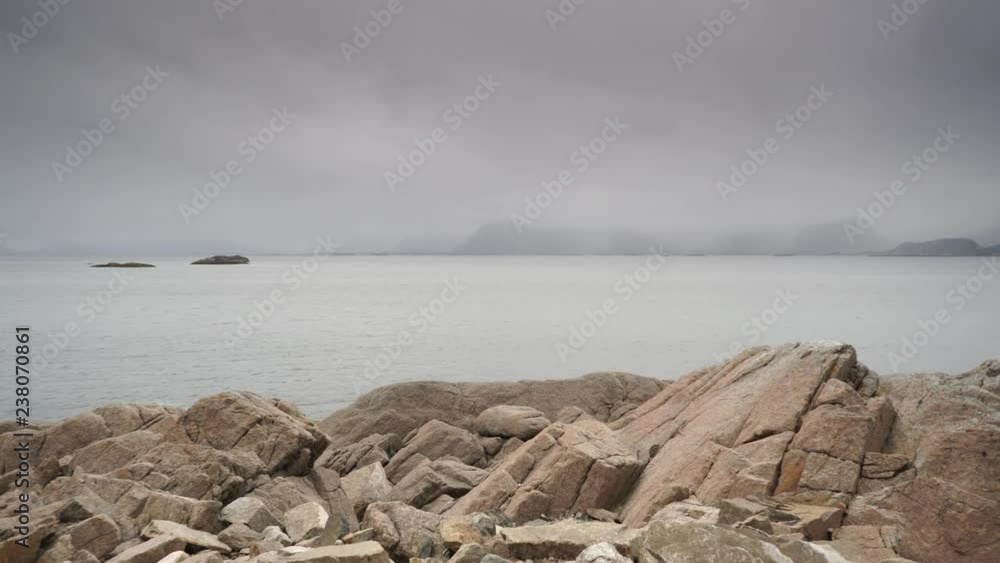 Sea landscape on Austvagoya island near Henningsvaer village, Lofoten Norway. Hazy rainy cloudy day, overcast weather in summer. Time lapse