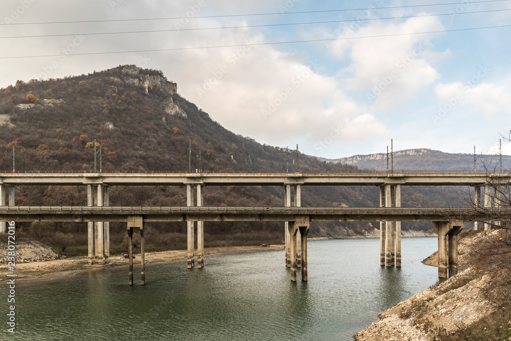 A railway bridge with trains passing over Tsonevo dam.