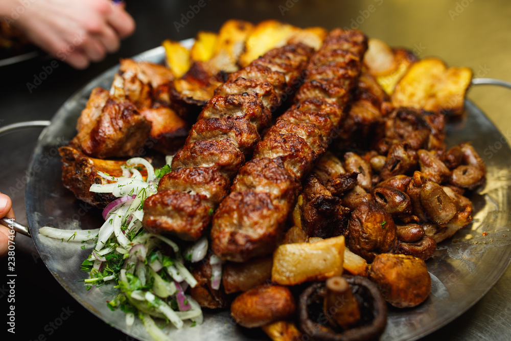 Lula kebab with vegetables. Minced mutton chop on the big steel plate