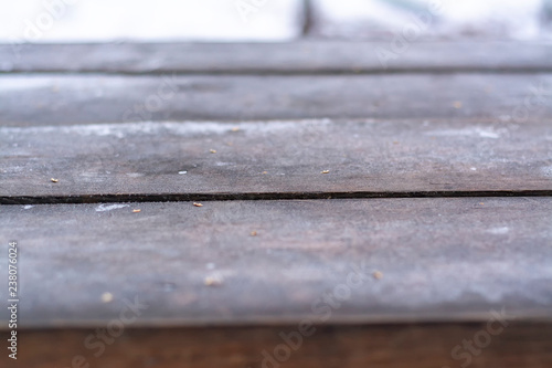 Tabletop wooden table with hoarfrost outdoors in winter