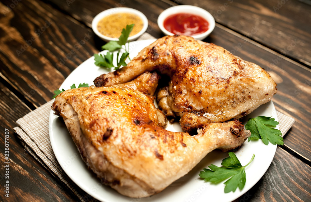 Chicken legs in a plate with mustard and ketchup on a wooden background. Chicken legs in a plate with mustard and ketchup on a wooden background.