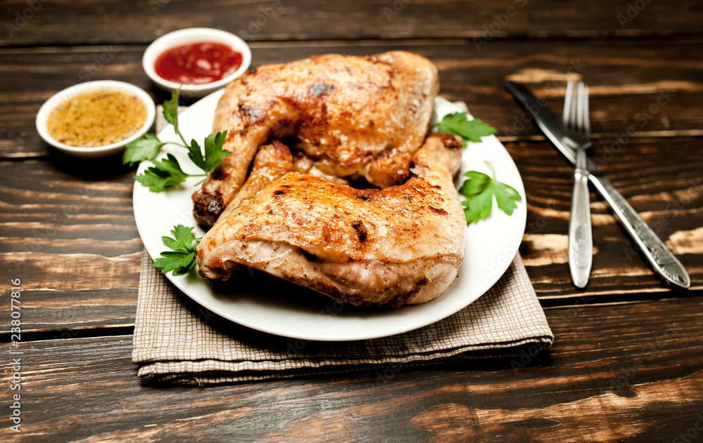 Chicken legs in a plate with mustard and ketchup on a wooden background. Chicken legs in a plate with mustard and ketchup on a wooden background.
