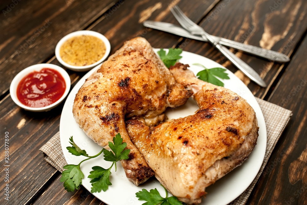 Chicken legs in a plate with mustard and ketchup on a wooden background. Chicken legs in a plate with mustard and ketchup on a wooden background.