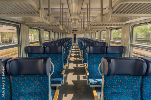 Interior of blue train with blue seat and wooden armrest