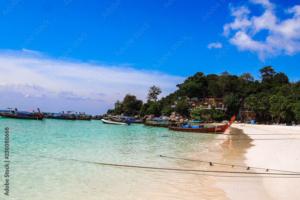 Obraz premium Travel Thailand. Idyllic Exotic Thai beach with turquoise water, palm trees and long tail boats - favourite tourist attraction. Popular tourist holiday/vacation destination. Bright colours. 