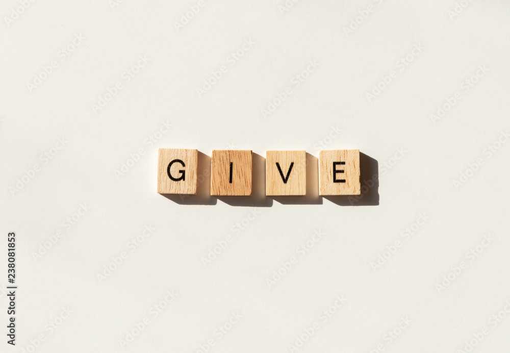 The word GIVE spelled in wooden letter tiles flat lay on white. The word GIVE spelled in wooden letter tiles flat lay on white.