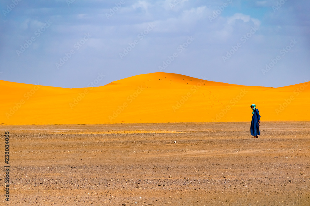 Lonely berber man walking in desert, Merzouga, Sahara Desert, Morocco, Africa