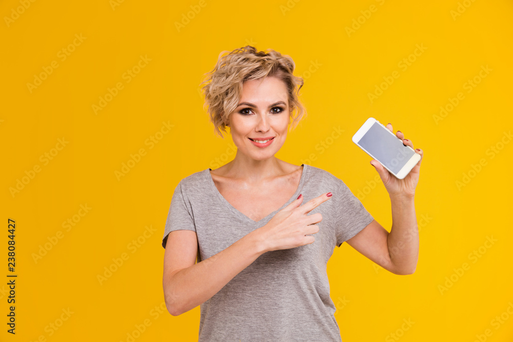 Fashion pretty woman using smartphone in rock black style over colorful orange background Fashion pretty woman using smartphone in rock black style over colorful orange background