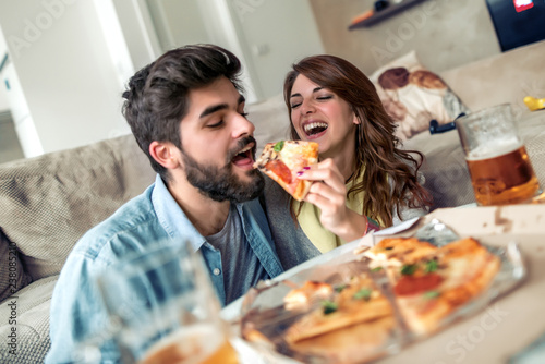Young couple eat pizza at home