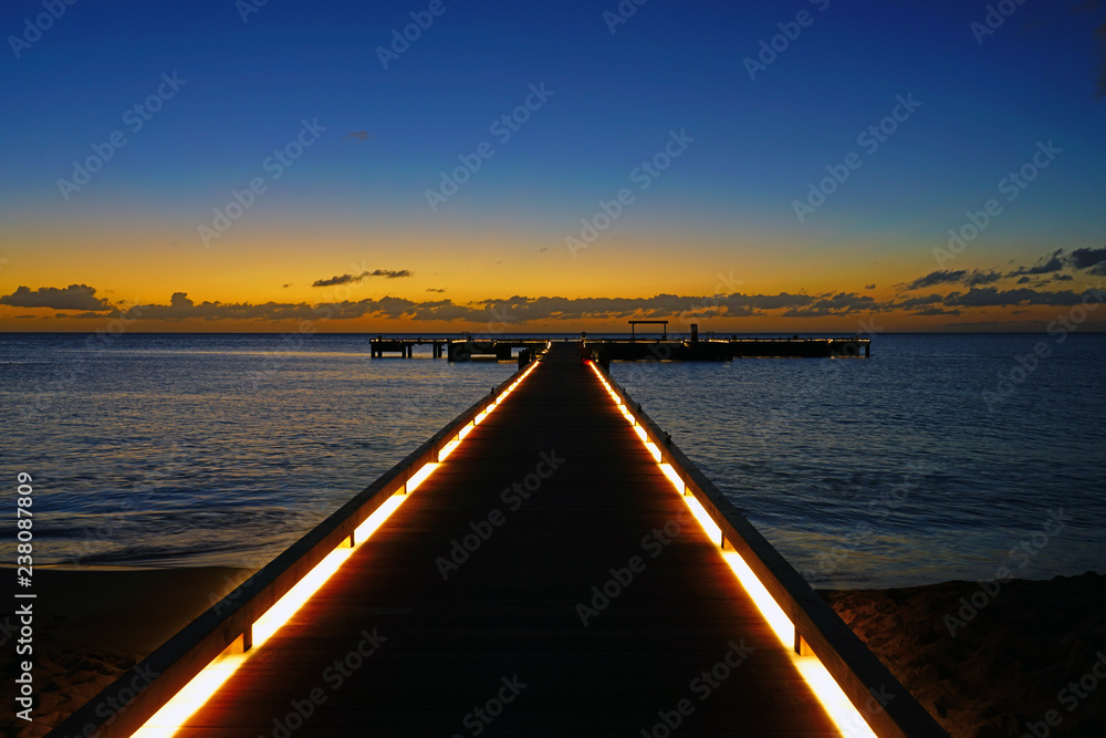 Sunset view of a lighted pier dock on the Caribbean Sea