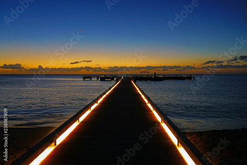 Sunset view of a lighted pier dock on the Caribbean Sea