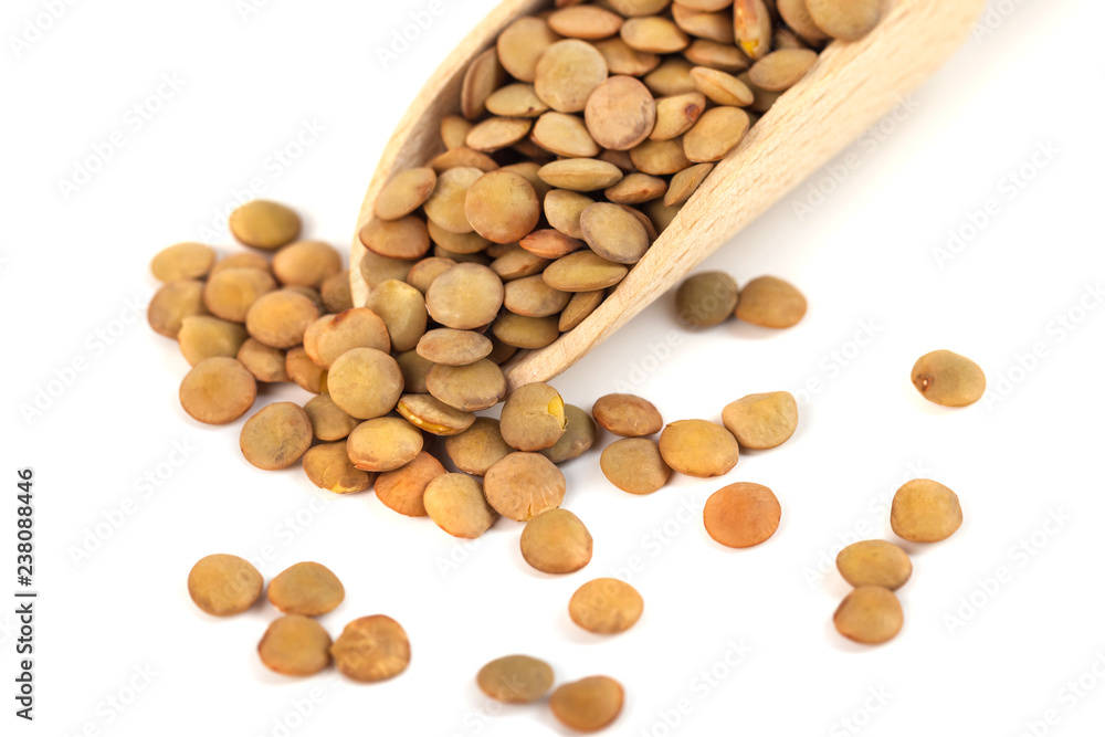 dry lentils on wooden spoon isolated on a white background dry lentils on wooden spoon isolated on a white background