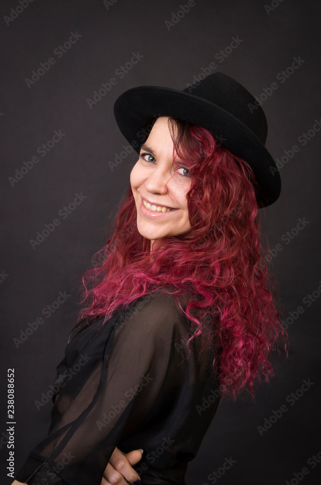 Emotional brunette in a hat with long hair posing in the Studio. Emotional brunette in a hat with long hair posing in the Studio.