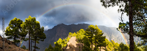 rainbow in front of mountains during stormy weather photo