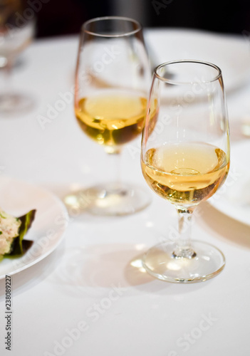Two wine glasses with sparkling orange wine on a restaurant table, ready for a degustation