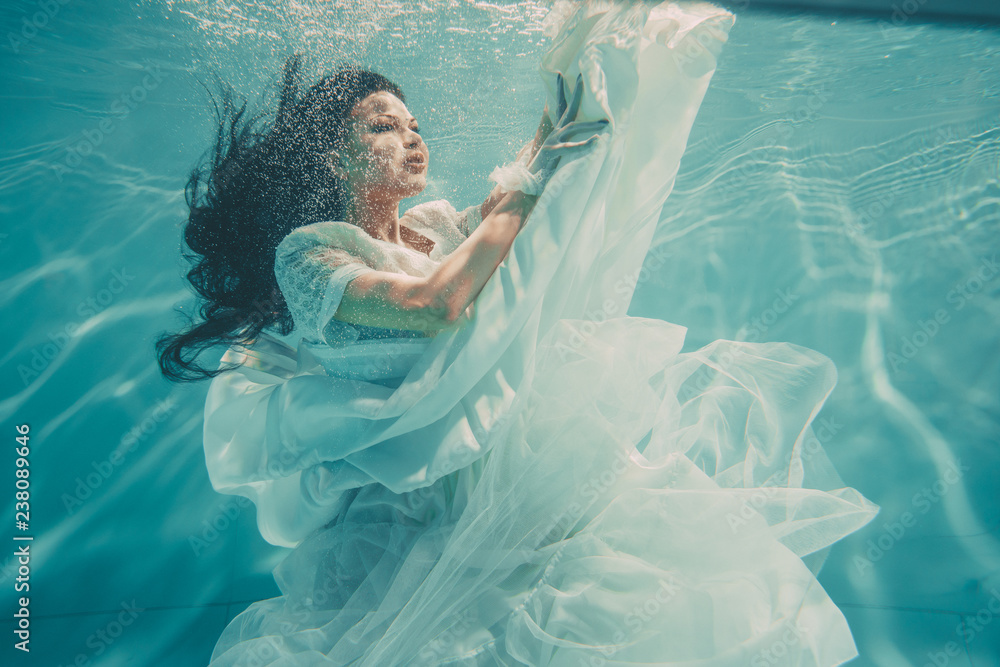 sexy young bride swimming underwater in white wedding dress, stockings and  gloves Stock Photo | Adobe Stock