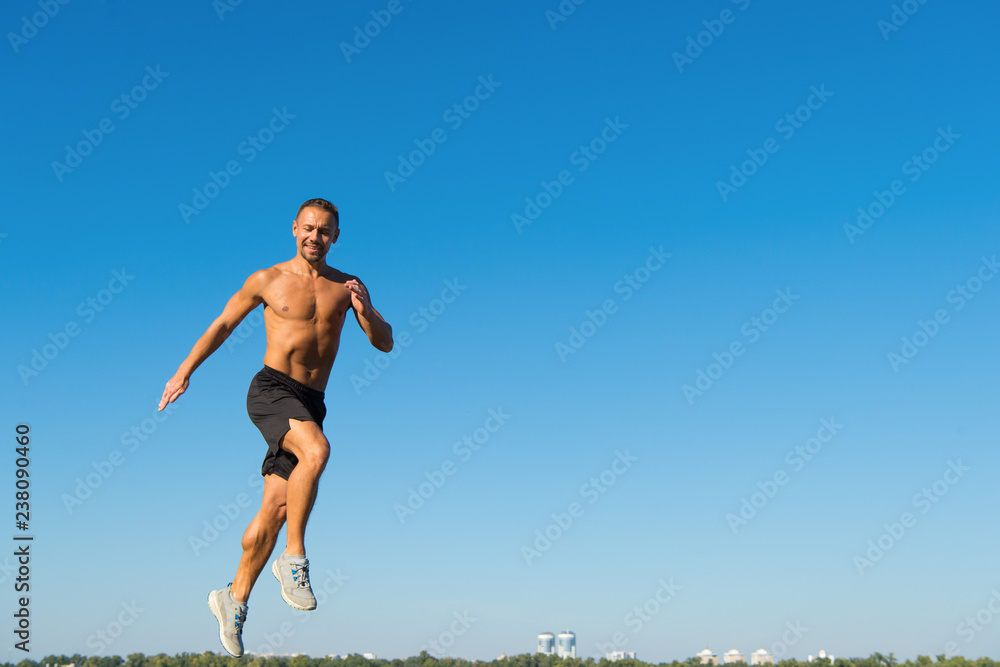 Man athlete muscular torso training outdoor. Runner training morning during sunrise. Sport motivation. Run healthy habit. Runner motion forward sky background copy space. Morning run fill with energy