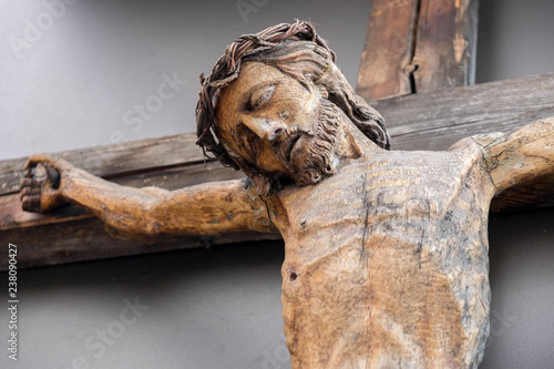 Holy Crucified Jesus Christ close-up. Ancient wooden sculpture. Bottom view. Sacred figure.