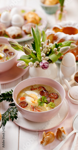 The sour soup (Żurek), polish Easter soup with the addition of smoked  sausage and a hard boiled egg in a ceramic bowl. Traditional Easter dish in Poland