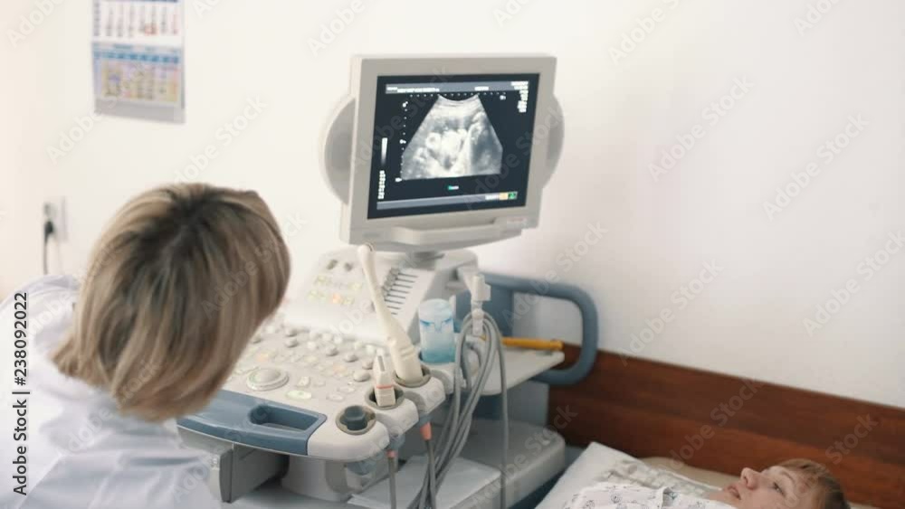 In the Hospital, Obstetrician Uses Transducer for Ultrasound/ Sonogram Screening / Scanning Belly of the Pregnant Woman. Pregnant woman at the reception at the gynecologist. 4k In the Hospital, Obstetrician Uses Transducer for Ultrasound/ Sonogram Screening / Scanning Belly of the Pregnant Woman. Pregnant woman at the reception at the gynecologist. 4k