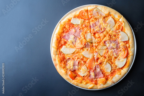 Italian pizza on a dark background with copy space, top view