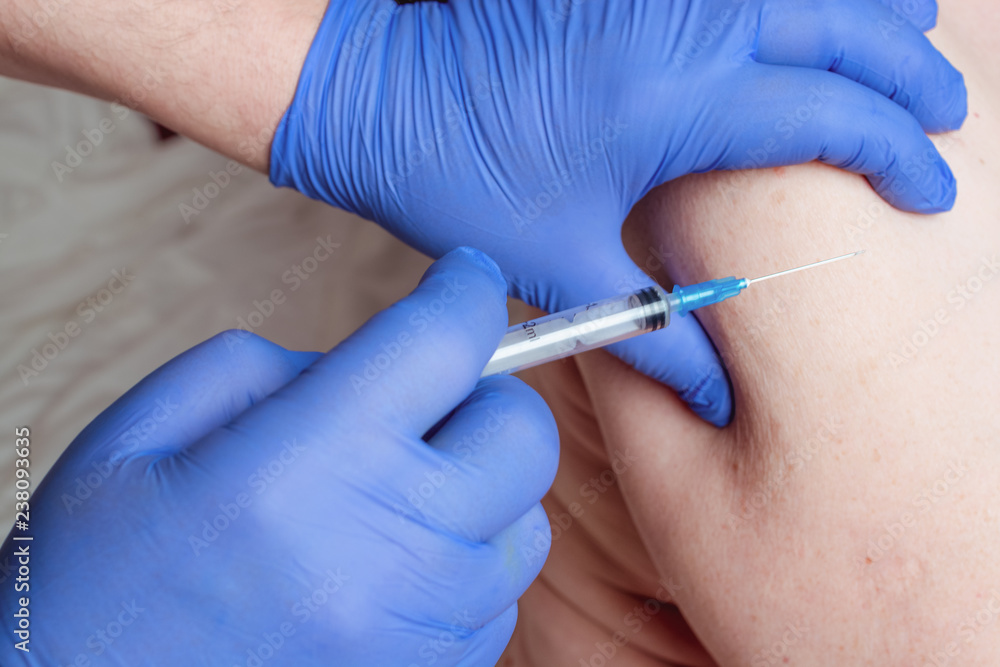 Doctor's hands in blue medical gloves vaccinate Doctor's hands in blue medical gloves vaccinate