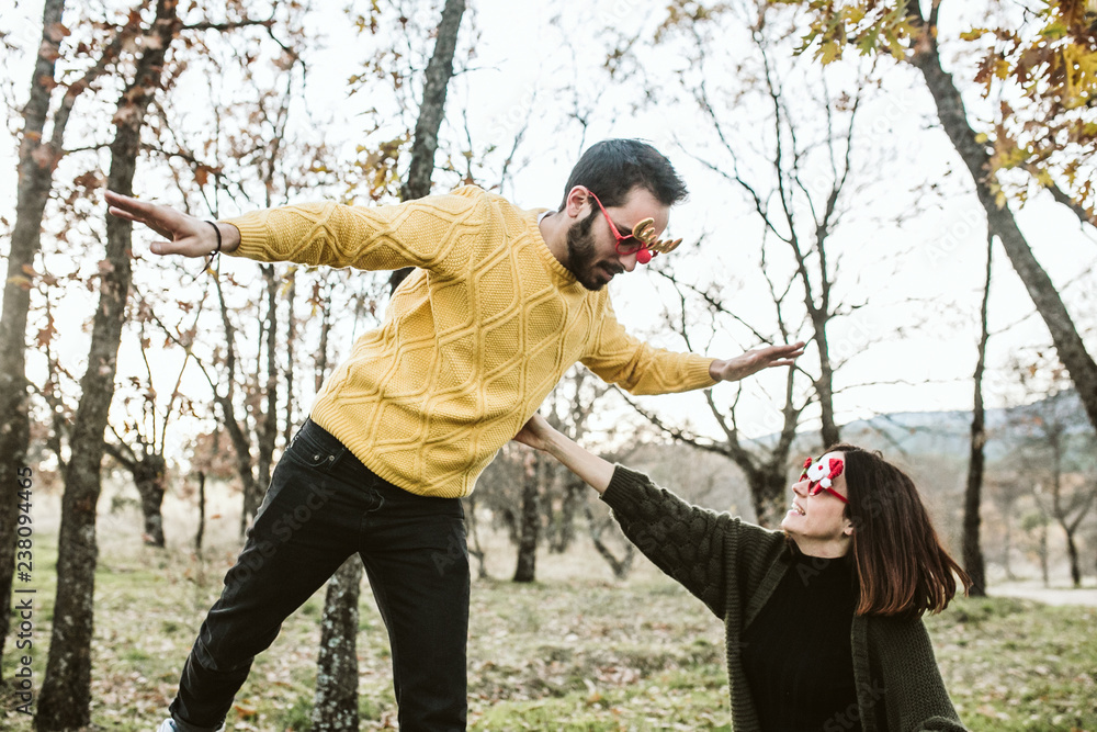 .Two friends enjoying their free time on the outdoor field. Both wear Christmas glasses, funny props, leisure time. Lifestyle. .Two friends enjoying their free time on the outdoor field. Both wear Christmas glasses, funny props, leisure time. Lifestyle.