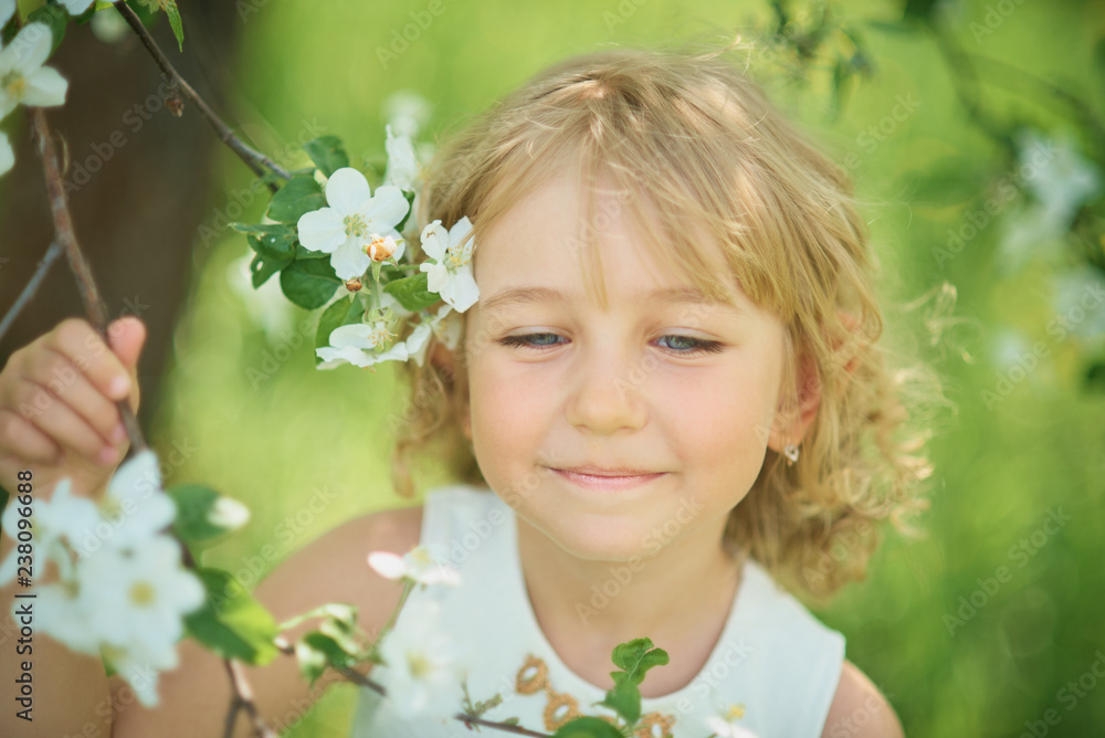 girl sniffing flowers of apple orchard. garden with flowering trees girl sniffing flowers of apple orchard. garden with flowering trees