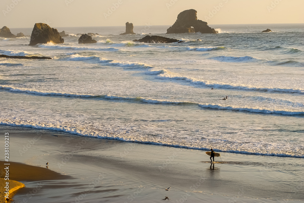 Fotografie Surfer on Beach with Sea Stacks