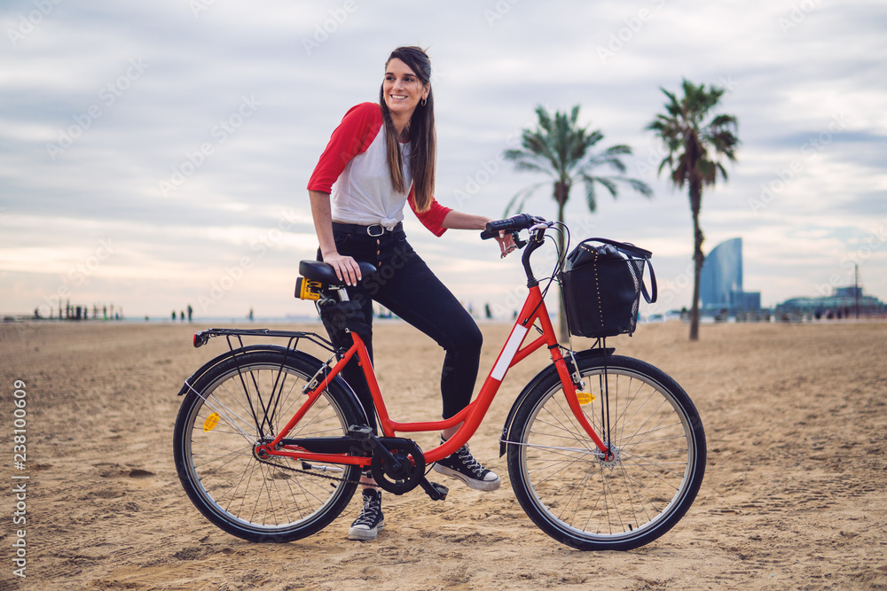Woman riding bicycle along beach sand at summer time. Healthy and sport concept Woman riding bicycle along beach sand at summer time. Healthy and sport concept