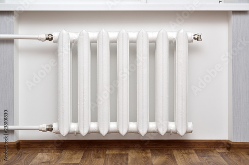 Pipes and a white heating radiator heat the room.