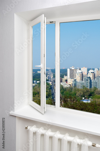 White window in empty room with heating and gray walls. Beautiful view from the window of the home.