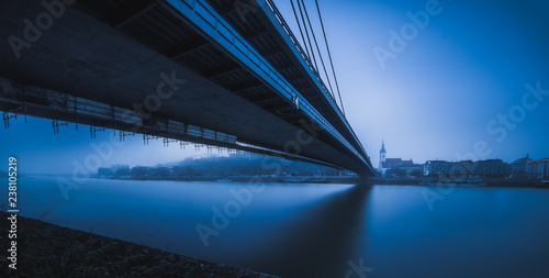 Photography Bratislava Skyline with Bridge over Danube River in Blue Tones
